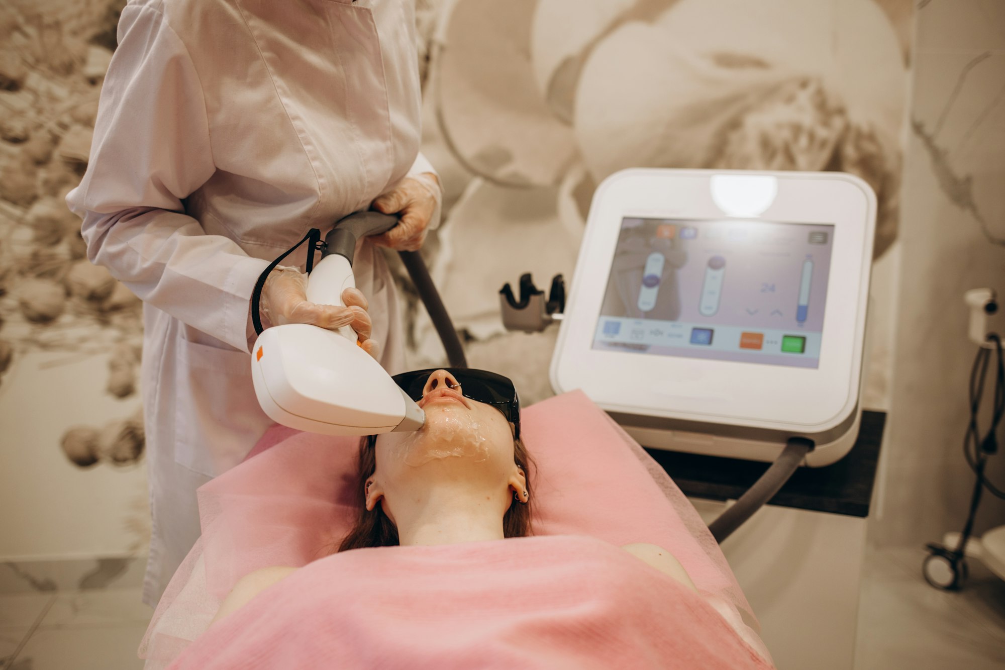 Beautiful woman having her facial hair removed by female beautician. Lazer epilation treatment,