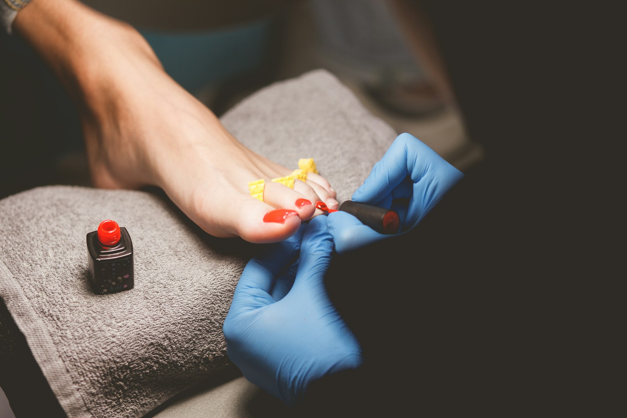 Master does pedicure for client. Pedicure process. Girl draws toenails