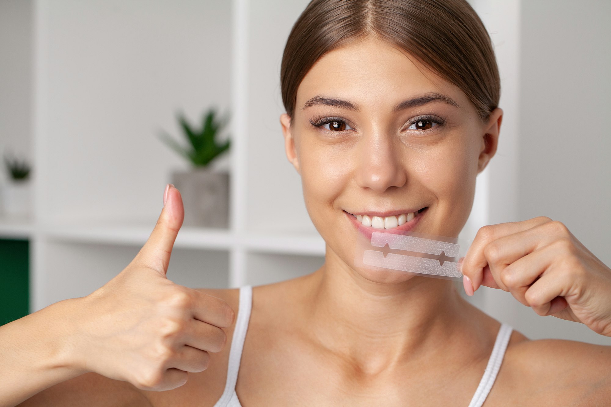 Teeth Whitening, Beautiful Smiling Woman Holding Whitening Strip.